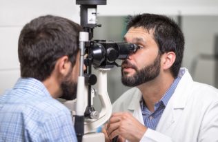 medico-oftalmologo-revisando-vision-ocular-joven-apuesto-clinica-moderna_56854-2432